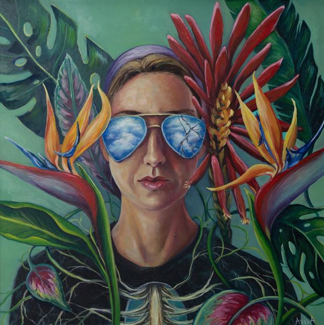 Self-portrait reflected in sunglasses, surrounded by tropical foliage