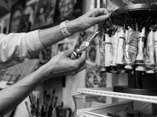 Black and white photo: choosing a paint color from the rack