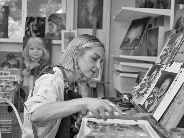 Black and white photo: mixing paint at the easel