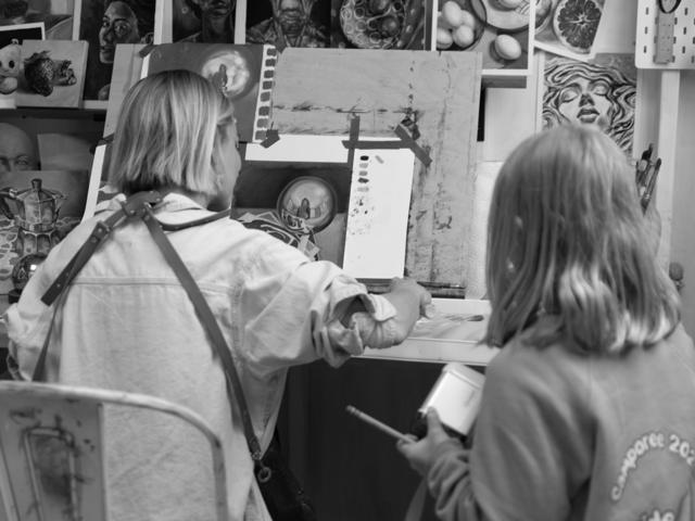 Black and white photo: painting together at the easel
